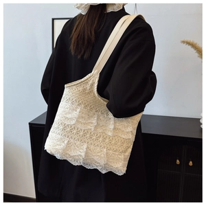 Detailed view of cream lace layered tote bag with ruffles and faux leather strap