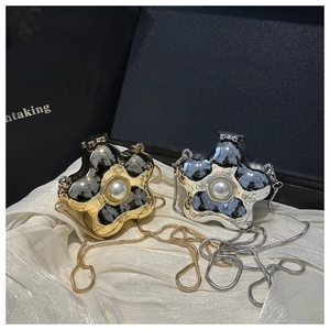 Detail showing gold and silver flower mini shell bags with large center pearls and chains