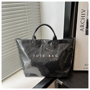 Detailaufnahme der schwarzen Shopper-Tasche mit Hochglanz-Finish und TOTE BAG Aufschrift