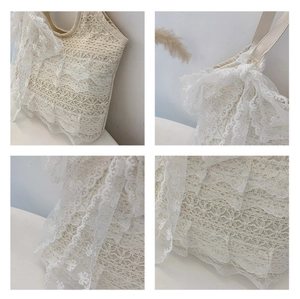 Detail of multi-layered lace tote bag with floral embroidery and bow decoration