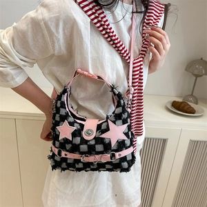 Borsa a tracolla a scacchi rosa con stelle e nappine indossata da una modella