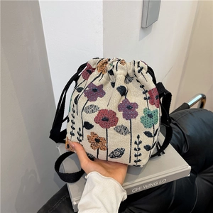 Floral jacquard bucket bag with black drawstring closure and shoulder strap
