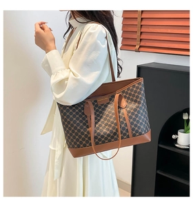 Detail of vintage tote bag with geometric print, brown leather trim and long handles