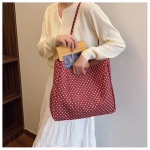 Detail of red polka dot canvas tote bag showing large capacity for books and essentials