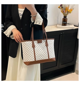 Detail of checkered tote bag featuring brown leather trim and canvas monogram pattern