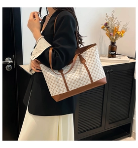 Detail of vintage canvas tote bag with geometric pattern and brown leather straps
