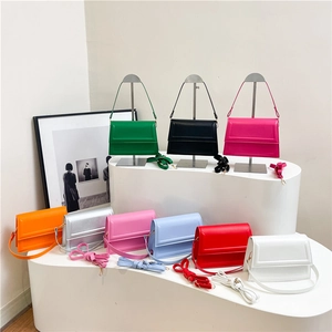 Bolsos bandolera cuadrados minimalistas en varios colores sobre un soporte blanco