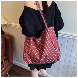 Close-up of red canvas tote bag with white polka dots showing large capacity and texture