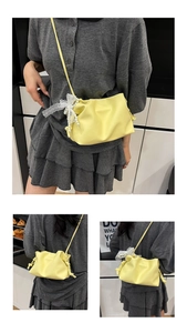 Detail of yellow pleated bucket bag with lace bow and pearl tassels in multiple views