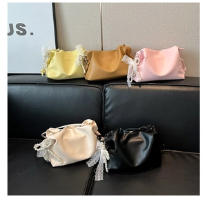 Detail of five assorted PU leather cosmetic bags with lace bows and pearl charms