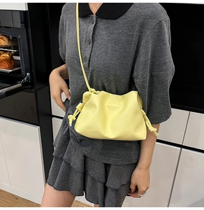 Detail of light yellow ruched cloud bag showing soft faux leather and drawstring strap