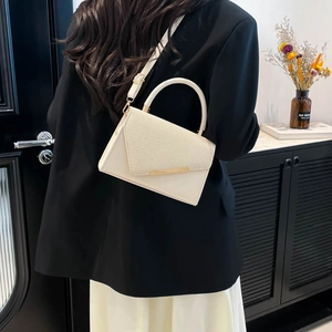 Minimalist beige crossbody bag with woven texture flap and elegant gold hardware details