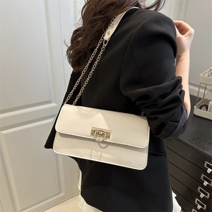 Chic cream white flap shoulder bag with golden D-ring lock and chain strap on a model
