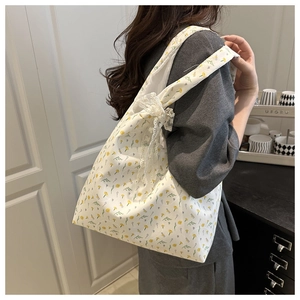 Detail of floral canvas tote bag with elegant lace bow and pearl tassel decoration