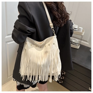Detail of white fringe shoulder bag featuring smooth PU leather and metallic eyelets