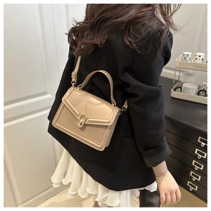 Detail of khaki crossbody bag featuring elegant gold metal clasp and stitching