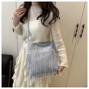 Détail du sac à bandoulière bohème bleu clair avec de longues franges et œillets