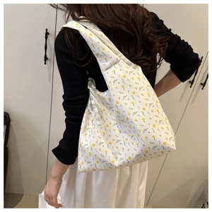 Detailed texture of floral canvas tote bag with delicate lace trim and yellow flower patterns