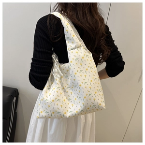 Detail of floral canvas tote bag with white lace crochet shoulder strap decoration