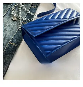 Detailed view of the royal blue chevron quilted shoulder bag with silver chain strap