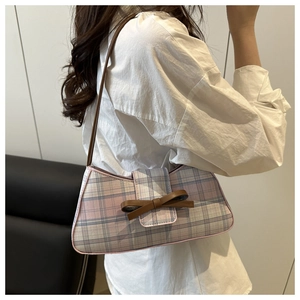 Pink and grey plaid baguette bag featuring a stylish brown bow and leather shoulder strap