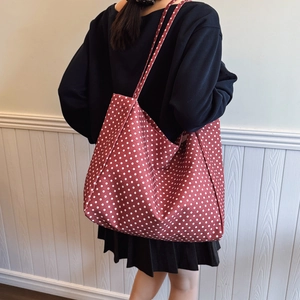 Retro red canvas tote bag with white polka dots for students shown on model