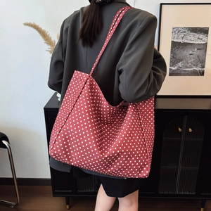 Retro red polka dot large canvas tote bag with shoulder straps shown on a model