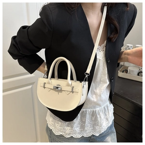 Dettaglio di una mini borsa a mano a semicerchio bianco crema con chiusura a scatto argento