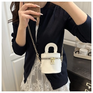 Détail du sac seau blanc avec double fermeture éclair et bandoulière en chaîne dorée