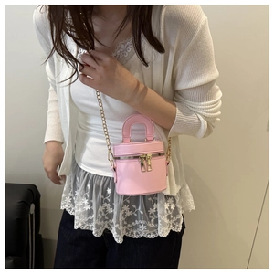 Mini sac seau rose avec chaîne dorée porté par un mannequin pour montrer le style
