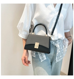 Detail of vintage square crossbody bag with contrast weave design and gold buckle