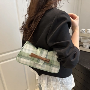Sac à bandoulière chic à carreaux vert et blanc avec nœud marron, porté par un mannequin