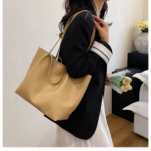 Fashionable khaki tote bag for women shown with model in a minimalist home setting