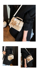 Detail of a cream vintage crossbody bag with woven texture and a plush bear charm