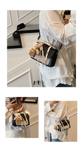Detail view of vintage-style flap square bag with woven texture and teddy bear charm