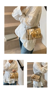 Detail of light khaki patchwork handbag featuring a cute bear charm and adjustable strap
