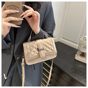 Détail du sac bandoulière matelassé beige avec fermoir H argenté et texture en cuir