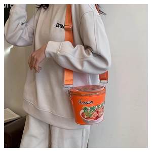 Dettaglio della borsa a secchiello creativa arancione a forma di noodle con tracolla
