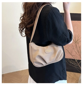 Dettaglio della borsa sottobraccio a pieghe a righe beige con forma a mezzaluna e trama