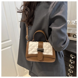Détail des coutures contrastées et du cuir matelassé sur le sac à bandoulière carré chic