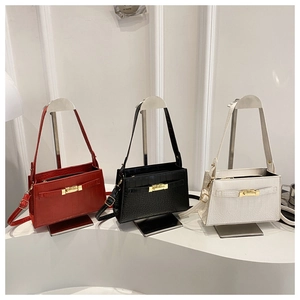 Three minimalist underarm bags in red, black, and white with crocodile texture