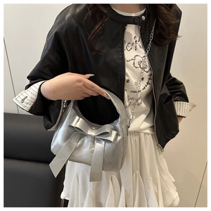 Silver metallic dumpling bag featuring a large decorative bow and elegant chain strap