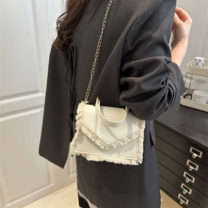 Retro white crossbody bag with tassels, gold chain strap, and elegant top handle design