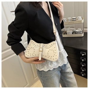 Détail du sac à bandoulière crème avec texture crocodile et clous dorés élégants