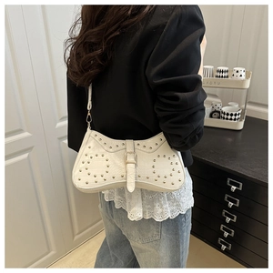 Détail du sac blanc à texture crocodile avec des rivets dorés élégants et chic