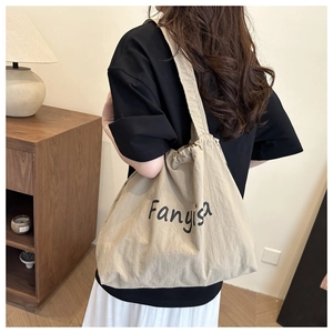 Detail of canvas tote bag featuring drawstring closure and stylish Fanyisa printed logo