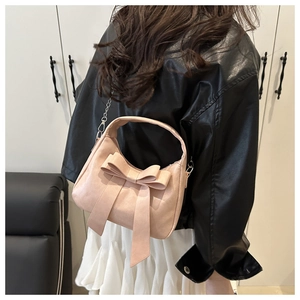 Close-up of pink bow handbag with soft PU leather texture and curved silhouette