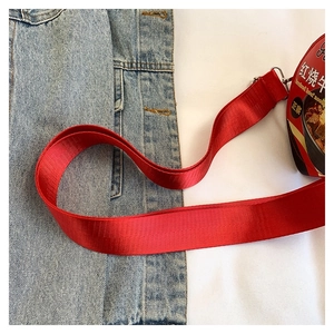 Dettaglio della tracolla in tessuto rosso e della fantasia della borsa di tagliatelle