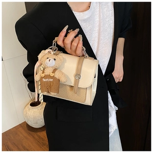 Chic beige crossbody bag with woven texture and a cute plush bear charm on handle