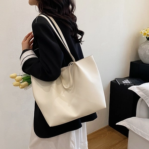 Minimalist cream tote bag in textured faux leather with slim shoulder straps for daily use
